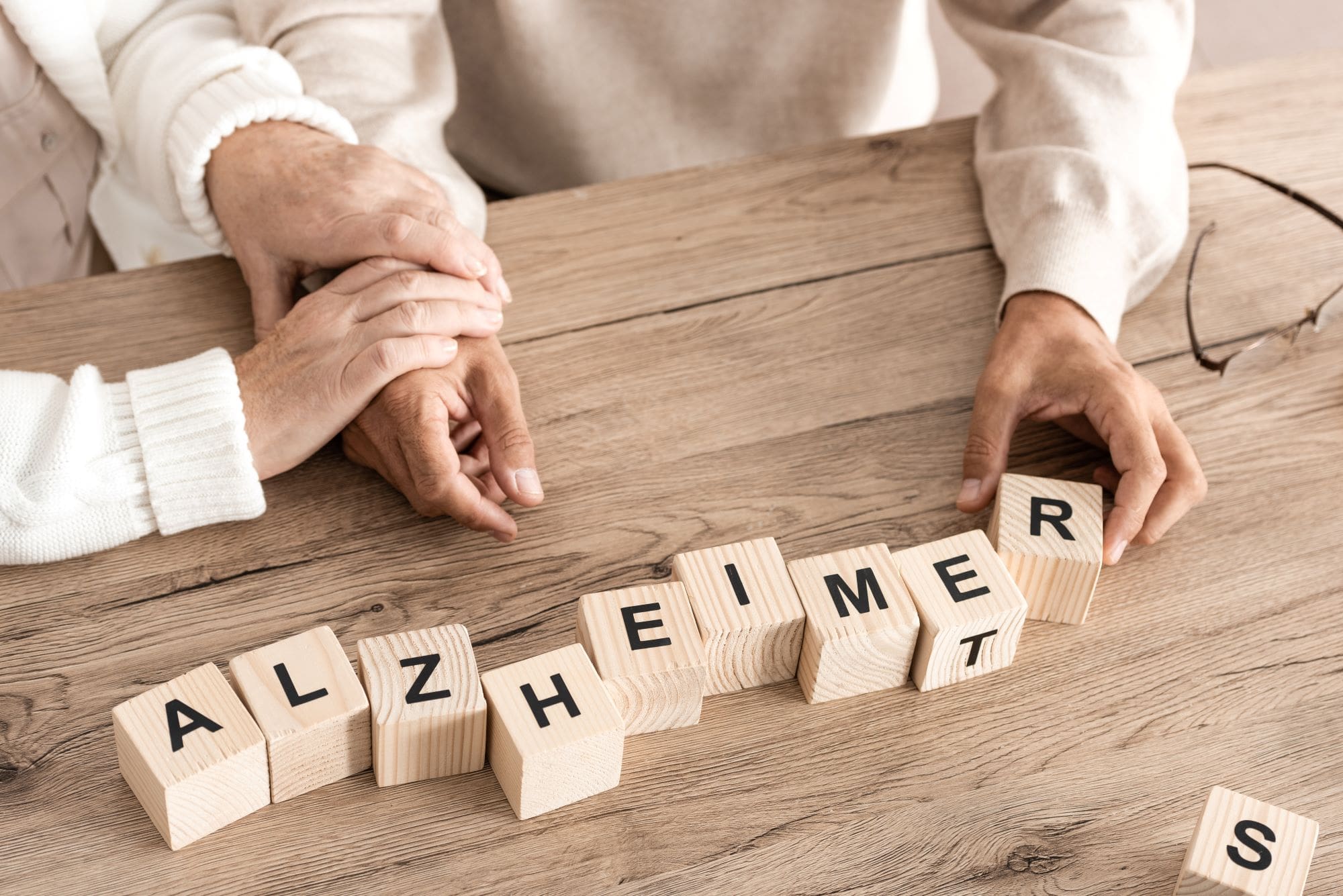 Alzheimers and older adults as shown in blocks and frail hands. Geromind works with Alzheimer's patients